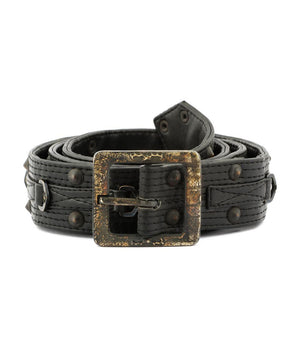 A black leather belt with a heavily distressed, textured bronze buckle and matching metal rivets, coiled on a white background.